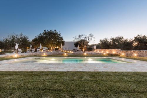 马丁纳弗兰卡Mandolario Trulli Resort的夜间在院子中间的游泳池
