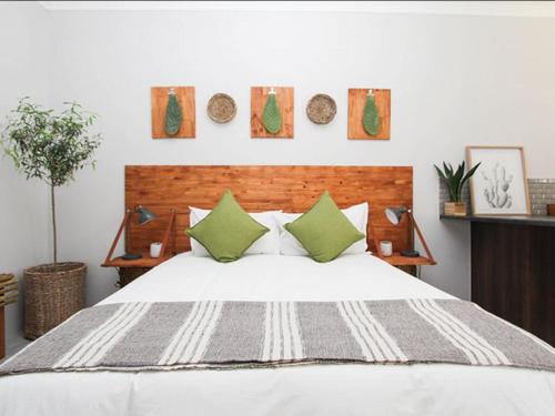 乌平通Maxton Boutique Hotel Upington的卧室配有带绿色枕头的白色床