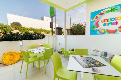 丽都玛里尼Marini Hotel B&B的餐厅设有白色的桌子和绿色的椅子