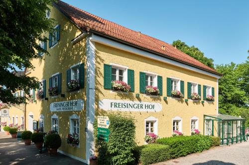 慕尼黑弗瑞森格酒店的一座建筑,上面有绿色百叶窗和鲜花