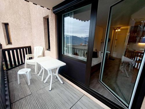 雷阿隆Résidence Relais - 2 Pièces pour 5 Personnes 654的阳台配有白色的桌椅和窗户。