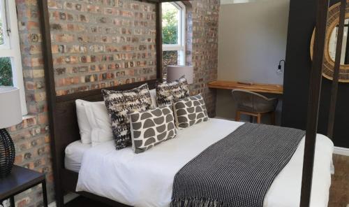 开普敦CLEMENT ONE, a villa for family & friends的一间卧室设有一张床和砖墙