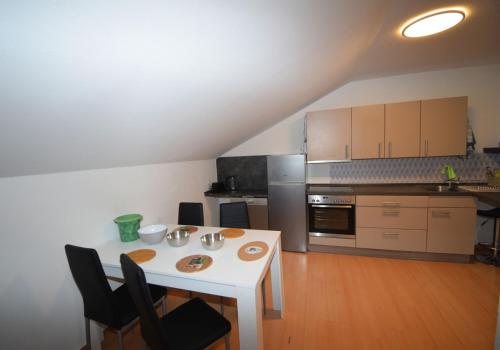 BuchenbergFerienunterkünfte maucher Immobilien的小厨房配有白色的桌子和椅子