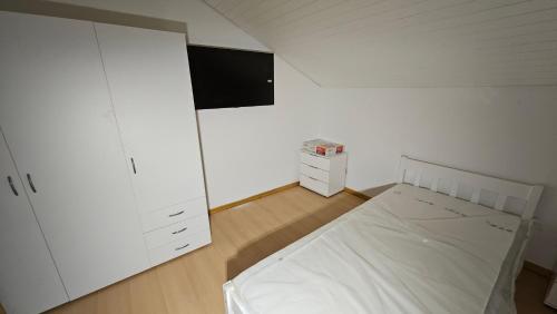 BuchenbergFerienunterkünfte maucher Immobilien的一间白色卧室,配有床和电视