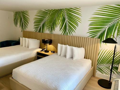 好莱坞The Harrison Hotel Downtown Hollywood的酒店客房带两张床和棕榈树壁画