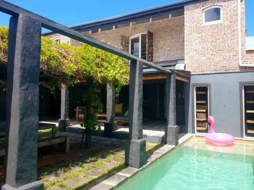 开普敦CLEMENT ONE, a villa for family & friends的一座房子,里面设有一座游泳池,里面装有粉红色玩具