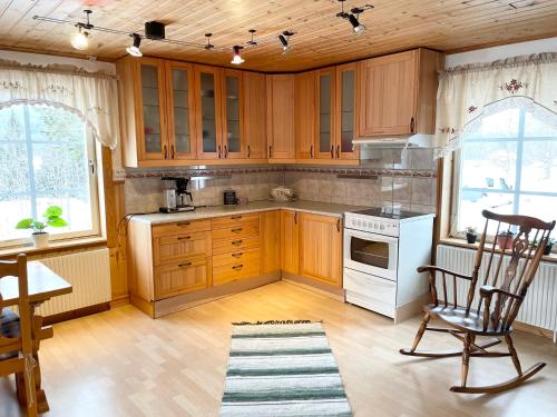 萨伦Lillstugan Sälen by的厨房配有木制橱柜和白色炉灶烤箱。