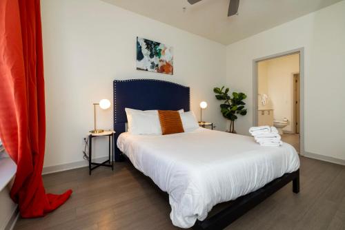 路易斯威尔Modern Nulu 2BR CozySuites Unit 03的一间卧室配有一张大床和蓝色床头板