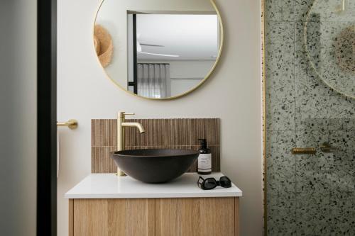 卡伦德拉Motel Caloundra的一间带碗水槽和镜子的浴室