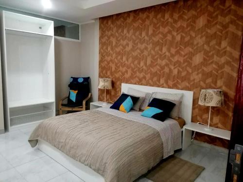 罗安达Lovely 5-Bed Suits - Guest House in Luanda的一间卧室配有一张带蓝色枕头的大床