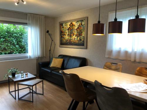 HattemerbroekVrijstaand Chalet in Bospark的客厅配有桌子和沙发