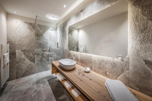 拉瓦莱Hotel Alpenrose Dolomites的一间带水槽和镜子的浴室