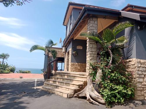 阿曼济姆托蒂Bayview Guest House的前面有棕榈树的房子