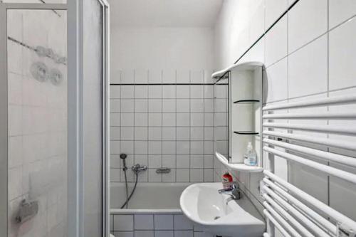 波茨坦Gründerzeitvilla in Potsdam的白色的浴室设有水槽和浴缸。