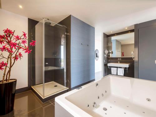 阿默斯福特阿默斯福特中心美居酒店的一间带大浴缸和淋浴的浴室