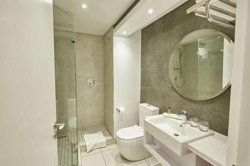 乌姆塔塔Garden Court Mthatha的一间带卫生间、水槽和镜子的浴室