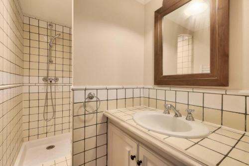 格里莫Les Bastides aux Restanques du Golfe de St Tropez - Maeva Home - Bastide spac 59的浴室配有盥洗盆和带镜子的淋浴