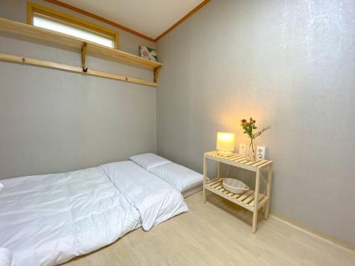 Hanok guesthouse Ann的一间卧室配有一张床和一张带台灯的桌子