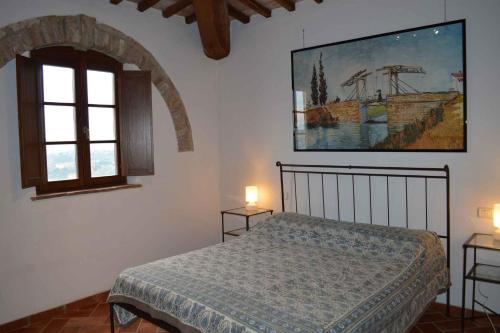 阿夏诺Apartment in Asciano/Toskana 24106的卧室配有一张床,墙上挂有绘画作品