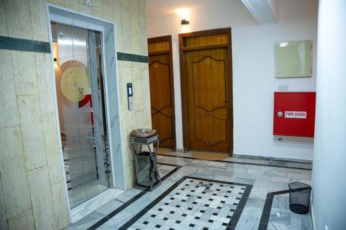 巴格达Malik Dijlah Hotel的走廊设有两扇门,铺有瓷砖地板
