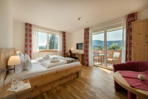 迈埃勒芬Sontheims Naturhotel & Spa的一间带大床的卧室和一个阳台
