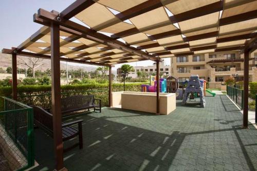 索瓦马Apartment F14 - Samarah Resort的公园内带长椅的凉亭和游乐场