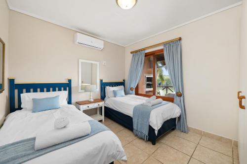 绍斯布鲁姆San Lameer Villa 10415 - 2 Bedroom Classic - 4 pax - San Lameer Rental Agency的一间卧室设有两张床和窗户。