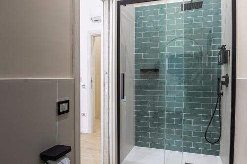 那不勒斯RUA DE MAR CHIATAMONE的浴室设有蓝色瓷砖玻璃淋浴间