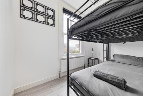 伦敦Stylish 2-Bedroom Flat in Walthamstow的一间卧室设有一张双层床和大窗户。