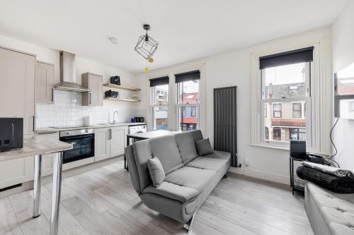 伦敦Stylish 2-Bedroom Flat in Walthamstow的带沙发的客厅和厨房