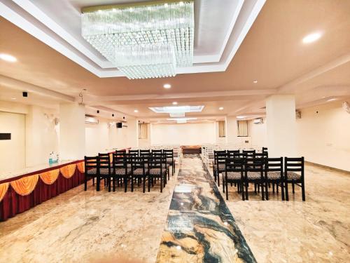 SatnaHotel Mahamaya的宴会厅配有黑色椅子和吊灯
