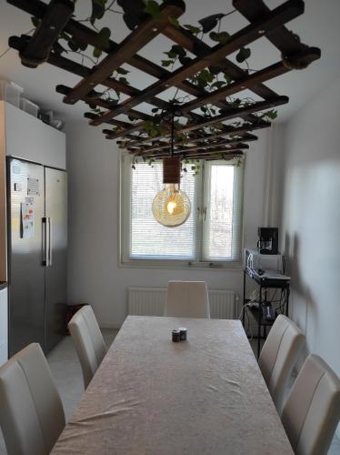 马尔默Privat apartment Bojan的一间带桌子和白色椅子的用餐室
