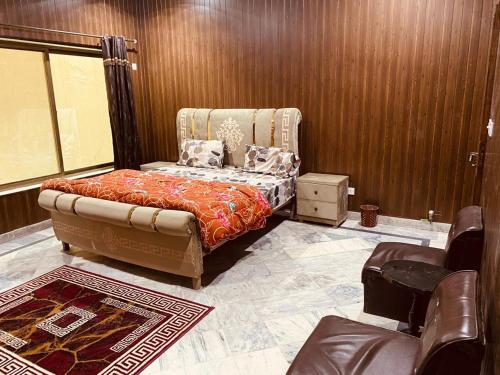 伊斯兰堡Kashee's Lodges的一间卧室,卧室内配有一张床和一把椅子