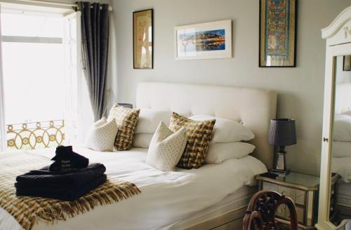 布里克瑟姆Ranscombe House的卧室配有带枕头的白色床和窗户。
