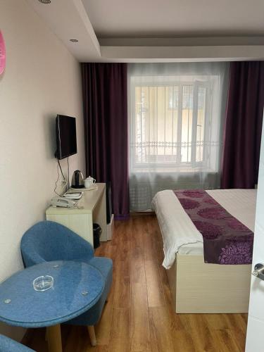 乌兰巴托Mandarin的酒店客房带一张床、一张桌子和椅子