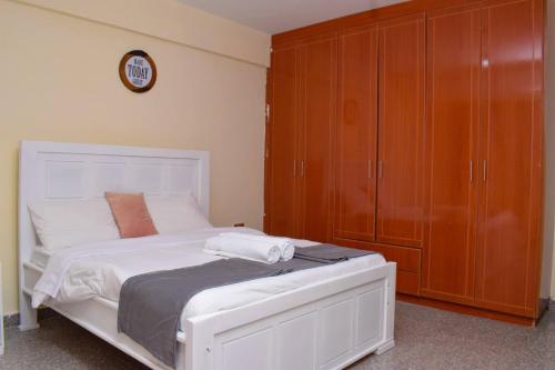 埃尔多雷特Saas Homestay的卧室配有白色的床和木制橱柜。