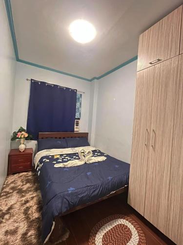 宿务JBR Cozy Bed & Breakfast的一间卧室配有床、梳妆台和蓝色的墙壁。