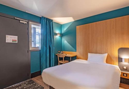 坎佩尔B&B HOTEL Quimper Nord Douarnenez的卧室配有白色的床和蓝色的墙壁