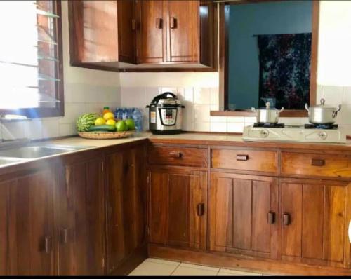 姆万扎Mambo & Jambo House的厨房配有木制橱柜和一碗水果
