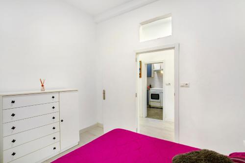 大加那利岛拉斯帕尔马斯Cristobal y concha的白色卧室配有粉红色的床和梳妆台