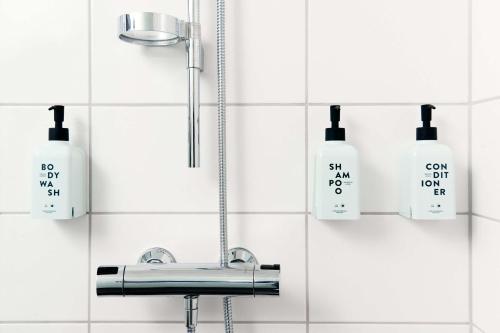斯德哥尔摩Scandic Södra Kajen的浴室设有水槽和墙上的肥皂瓶。