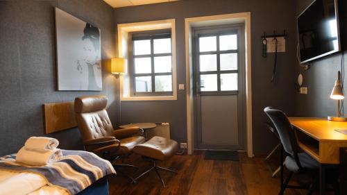Vestnes韦斯特内斯峡湾酒店的卧室配有一张床、一张桌子和椅子
