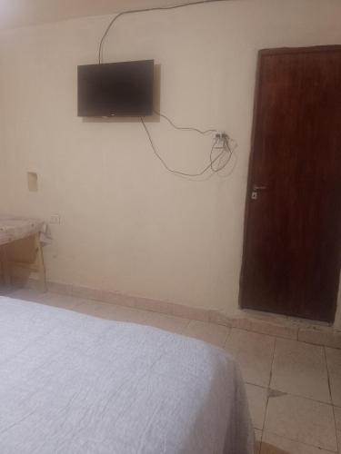 普尔马马尔卡Alojamiento familiar doña justa的卧室配有一张床,墙上配有电视。