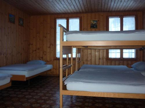 施特歇尔贝格Alpenhof Mountain Lodge的木墙客房的两张双层床