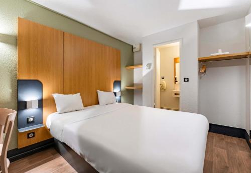 维拉尔B&B HOTEL Saint-Etienne La Terrasse的客房内一张大白色的床
