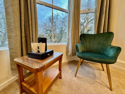贝图瑟科伊德古易迪尔酒店的客厅配有绿色椅子和桌子