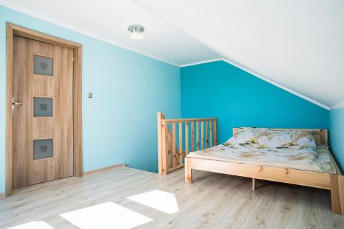 厄尔科Agroturystyka Golubie的一间卧室设有蓝色的墙壁和木门。