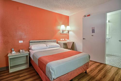 弗雷斯诺弗雷斯诺 - 布莱克斯通南6号汽车旅馆的酒店客房,配有一张橙色墙壁的床