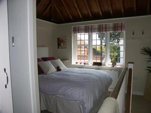 温奇尔西The Gazebo in Winchelsea的一间卧室设有一张床和两个窗户。