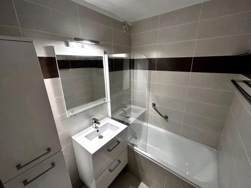 里蒙纽耶Résidence Oisans - 2 Pièces pour 6 Personnes 824的浴室配有盥洗盆、镜子和浴缸